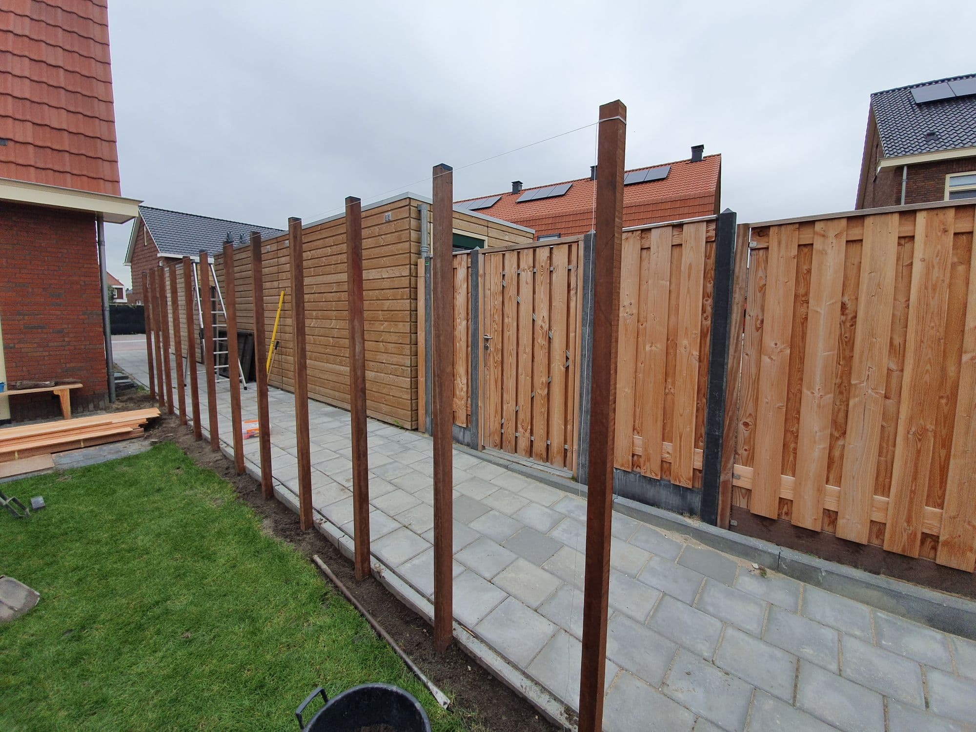Houten schutting met palen tijdens de plaatsing
